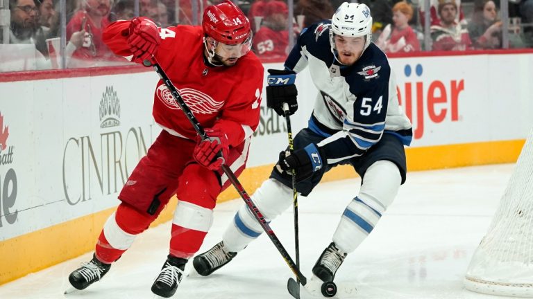 Winnipeg Jets' Dylan Samberg (54) defends Detroit Red Wings centre Robby Fabbri (14) in the second period of an NHL hockey game Thursday, Jan. 13, 2022, in Detroit. (Paul Sancya/AP)