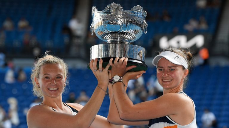 Barbora Krejcikova, right, and Katerina Siniakova of the Czech Republic hold their trophy aloft after defeating Anna Danilina of Kazakhstan and Beatriz Haddad Maia of Brazil in the women's doubles final at the Australian Open tennis championships in Sunday, Jan. 30, 2022, in Melbourne, Australia. (Andy Brownbill/AP)