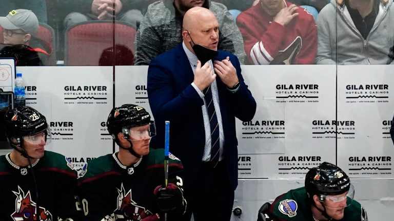 Arizona Coyotes head coach Andre Tourigny, center top, yells at the officials as the stands behind Coyotes' Antoine Roussel (26), Riley Nash (20) and Christian Fischer (36) during the third period of an NHL hockey game against the Nashville Predators, Saturday, Jan. 8, 2022, in Glendale, Ariz. (Ross D. Franklin/AP)