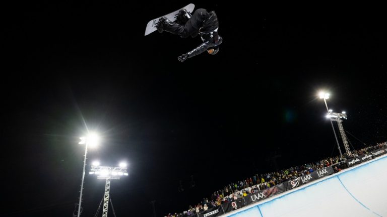 Shaun White of the United States, flies in the air during the final run of the snowboard halfpipe competition at the Laax Open, on Saturday, Jan. 15, 2022, in Laax, Switzerland. White finished third, marking his first podium finish since he won his third Olympic gold medal in 2018 and all but cementing his spot at next month’s games in Beijing. (Gian Ehrenzeller/Keystone via AP)