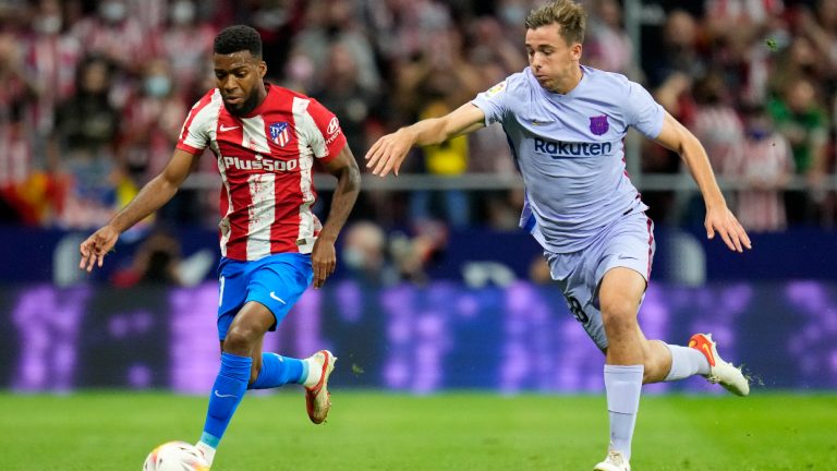 Barcelona's Nico Gonzalez, right, chases Atletico Madrid's Thomas Lemar during the La Liga soccer match between Atletico Madrid and Barcelona at the Estadio Wanda Metropolitano in Madrid, Saturday, Oct. 2, 2021. (Manu Fernandez/AP)
