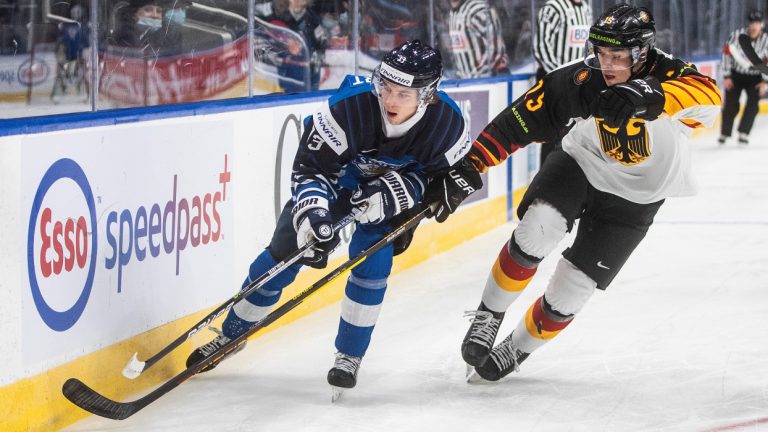Finland's Brad Lambert (33) is chased by Germany's Luca Münzenberger (15) during first period IIHF World Junior Hockey Championship action in Edmonton, Sunday, Dec. 26, 2021. (Jason Franson/CP)