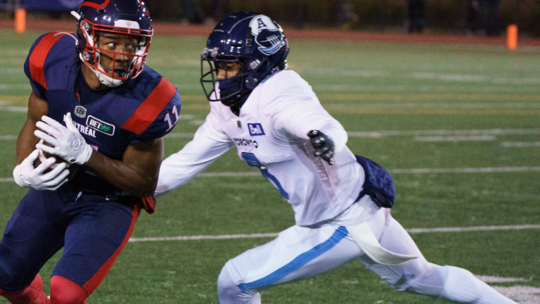 Montreal Alouettes wide receiver Kaion Julien-Grant avoids a tackle by Toronto Argonauts defensive back Chris Edwards during second quarter CFL football action in Montreal on Friday, October 22, 2021. (CP)