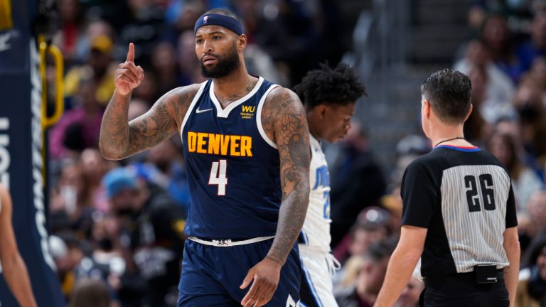 Denver Nuggets center DeMarcus Cousins, front, gestures after scoring a basket and drawing a foul by Orlando Magic forward Admiral Schofield during the second half of an NBA basketball game Monday, Feb. 14, 2022, in Denver. The Nuggets won 121-111. (AP Photo/David Zalubowski)