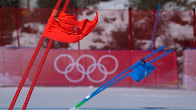 Gate flags bend in the wind after high winds caused a delay in the start of the mixed team parallel skiing event at the 2022 Winter Olympics, Saturday, Feb. 19, 2022, in the Yanqing district of Beijing. (AP Photo/Robert F. Bukaty)