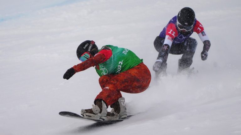 Canada's Meryeta O'Dine crosses the finish line ahead of United States' Faye Gulini during their leg of the mixed team snowboard cross at the 2022 Beijing Winter Olympics. (Sean Kilpatrick/CP)