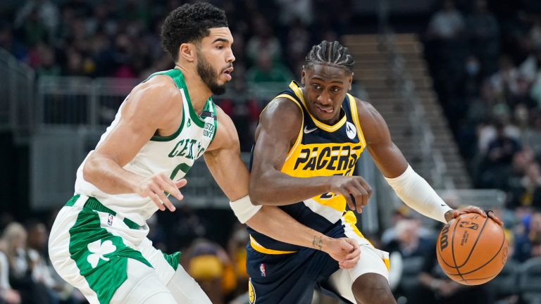 Indiana Pacers guard Caris LeVert (22) is defended by Boston Celtics forward Jayson Tatum (0) during the first half of an NBA basketball game, Wednesday, Jan. 12, 2022, in Indianapolis. (Darron Cummings/AP)