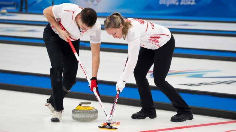 Canada's Rachel Homan and John Morris sweep a rock as they face Great Britain's Bruce Mouat and Jennifer Dodds in mixed doubles curling play at the 2022 Winter Olympics in Beijing on Thursday, February 3, 2022. (Paul Chiasson/THE CANADIAN PRESS)