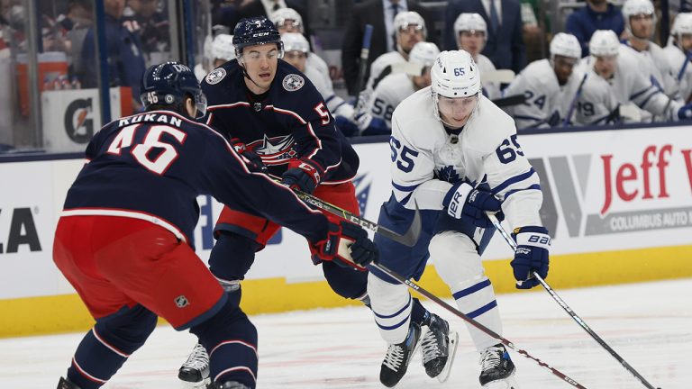 Toronto Maple Leafs' Ilya Mikheyev, right, carries the puck across the blue line as Columbus Blue Jackets' Dean Kukan, left, and Gavin Bayreuther defend during the first period of an NHL hockey game. (Jay LaPrete/AP)