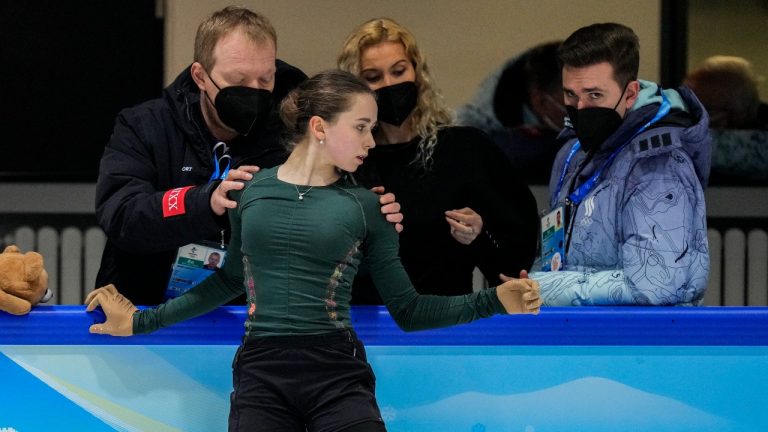 Kamila Valieva, of the Russian Olympic Committee, foreground, talks with her coaching team at the 2022 Winter Olympics, Saturday, Feb. 12, 2022, in Beijing. (Bernat Armangue/AP Photo)