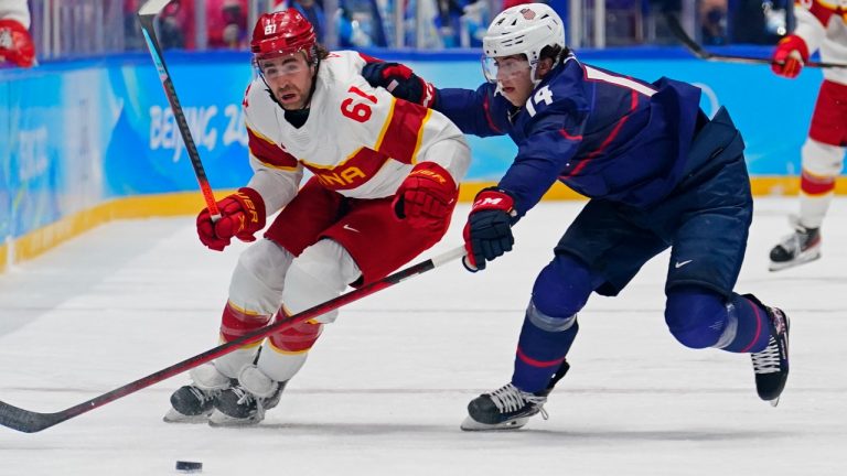 China's Ethan Werek (61) and United States' Brock Faber (14) chase the puck during a preliminary round men's hockey game at the 2022 Winter Olympics, Thursday, Feb. 10, 2022, in Beijing. (Matt Slocum/AP Photo)