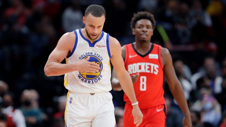 Golden State Warriors guard Stephen Curry, left, pats his chest in front of Houston Rockets forward Jae'Sean Tate (8) after making a 3-point basket during the second half of an NBA basketball game Monday, Jan. 31, 2022, in Houston. (Michael Wyke/AP)