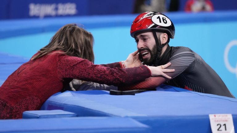 Canada's Steven Dubois is congratulated by teammate Kim Boutin after winning the silver medal in the men's 1,500-metre short-track speedskating event at the Beijing Winter Olympics in Beijing, China, on Wednesday, Feb. 9, 2022. (Paul Chiasson/THE CANADIAN PRESS)