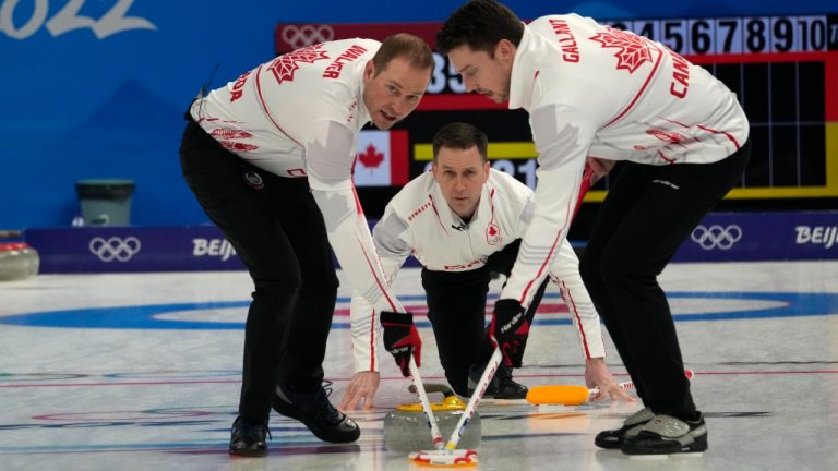 Canada skip Brad Gushue (centre) watches his shot as Geoff Walker (left) and Brett Gallant sweep during men's curling action against Denmark at the Beijing Winter Olympics in Beijing, China, on Wednesday, Feb. 9, 2022. (Ryan Remiorz/CP)