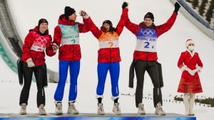 Canada's Alexandria Loutitt, left, celebrates with teammates Matthew Soukup, Abigail Strate and Mackenzie Boyd-Clowes during the the venue ceremony after winning a bronze in the ski jumping mixed team event at the 2022 Winter Olympics, Monday, Feb. 7, 2022, in Zhangjiakou, China. (Matthias Schrader/AP Photo)