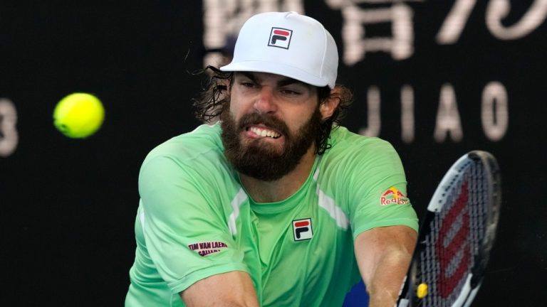 Reilly Opelka of the U.S. plays a backhand return to Denis Shapovalov of Canada during their third round match at the Australian Open tennis championships in Melbourne, Australia, Friday, Jan. 21, 2022. (Simon Baker/AP)