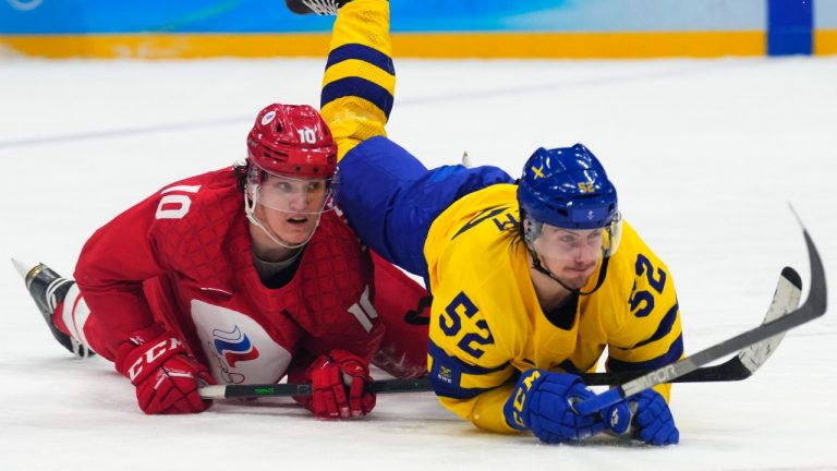 Sweden's Philip Holm, right, and Russian Olympic Committee's Dmitri Voronkov fall on the ice during a men's semifinal hockey game at the 2022 Winter Olympics, Friday, Feb. 18, 2022, in Beijing. (Petr David Josek/AP Photo)