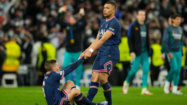 PSG's Kylian Mbappe helps teammate Marco Verratti after their loss in the Champions League, round of 16, second leg match against (Manu Fernandez/AP)