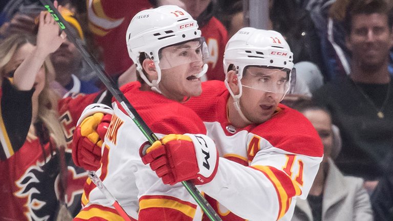 Calgary Flames' Matthew Tkachuk, left, and Mikael Backlund, of Sweden, celebrate Tkachuk's goal against the Vancouver Canucks during the first period of an NHL hockey game in Vancouver, on Saturday, March 19, 2022. (Darryl Dyck/CP)