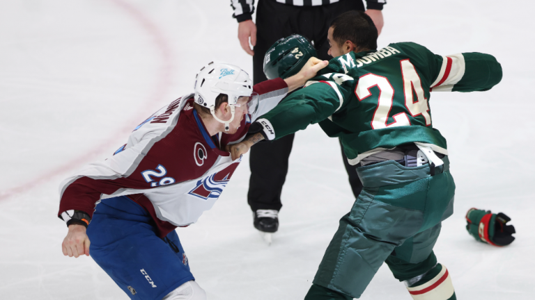 Colorado Avalanche center Nathan MacKinnon (29) fights with Minnesota Wild defenseman Matt Dumba (24) during the third period Sunday, March 27, 2022, in St. Paul, Minn. (AP)
