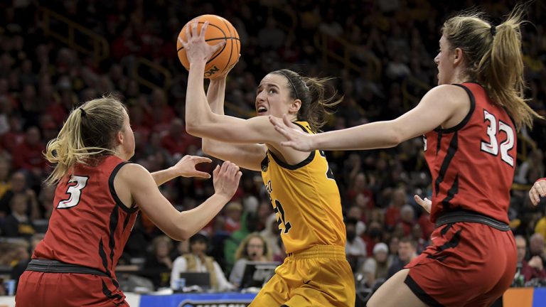 Iowa guard Caitlin Clark (22) drives the ball between Illinois State's Mary Crompton (3) and Kate Bullman (32) during the second half of a first-round game in the NCAA women's college basketball tournament. (Ron Johnson/AP)