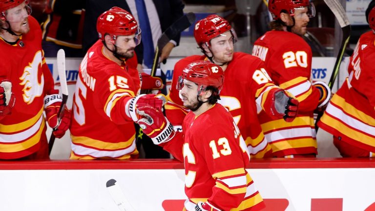 Calgary Flames left wing Johnny Gaudreau (13) celebrates his goal against the Montreal Canadiens with teammates on the bench during second period NHL hockey action in Calgary on Thursday, March 3, 2022. (Larry MacDougal/CP)