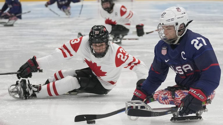 Josh Paul, right, of the United States and Liam Hickey of Canada battle for the puck during their para ice hockey finals match at the 2022 Winter Paralympics. (Dita Alangkara/AP)