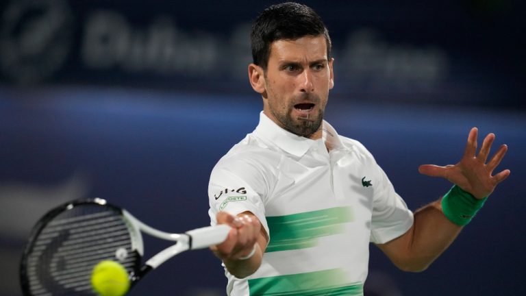 Serbia's Novak Djokovic returns the ball to Russia's Karen Khachanov during a match of the Dubai Duty Free Tennis Championship in Dubai, United Arab Emirates, Wednesday, Feb. 23, 2022. (Kamran Jebreili/AP)