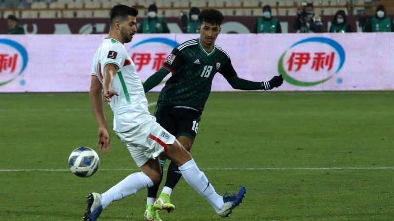 Abdalla Ramadan Bekheet of U.A.E., right, shoots the ball as Iran's Saied Ezatolahi defends during their 2022 World Cup qualifier soccer match, at the Azadi stadium in Tehran, Iran, Tuesday, Feb. 1, 2022. (Vahid Salemi/AP Photo)