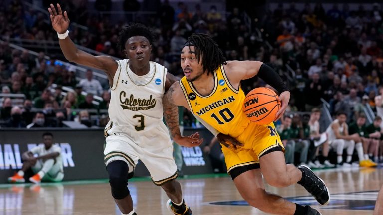 Michigan guard Frankie Collins (10) drives past Colorado State guard Kendle Moore (3) during the second half of a college basketball game in the first round of the NCAA tournament in Indianapolis, Thursday, March 17, 2022. (Michael Conroy/AP)