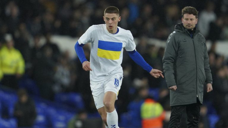Everton's Vitaliy Mykolenko from Ukraine, wearing the Ukrainian flag on his t-shirt, warms-up before the English FA Cup 5th round soccer match between Everton and Boreham Wood at Goodison Park in Liverpool, England, Thursday, March 3, 2022. (Jon Super/AP)