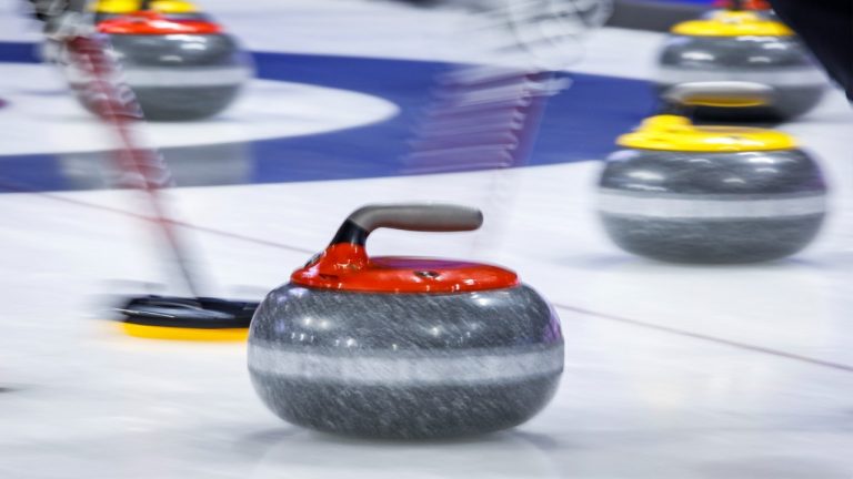 Players sweep a rock at the Tim Hortons Brier in Lethbridge, Alta., Sunday, March 6, 2022. (Jeff McIntosh/CP)