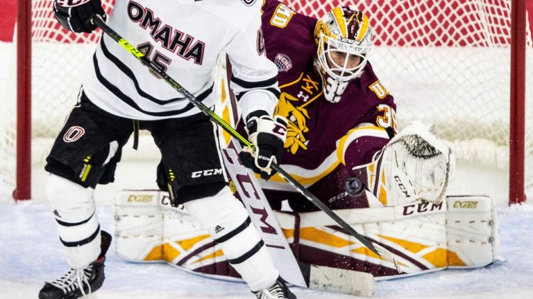 Omaha's Joey Abate watches Minnesota-Duluth goalie Ryan Fanti make a third-period save during a college hockey game Tuesday, Dec. 1, 2020, in Omaha, Neb. (Chris Machian/Omaha World-Herald via AP)