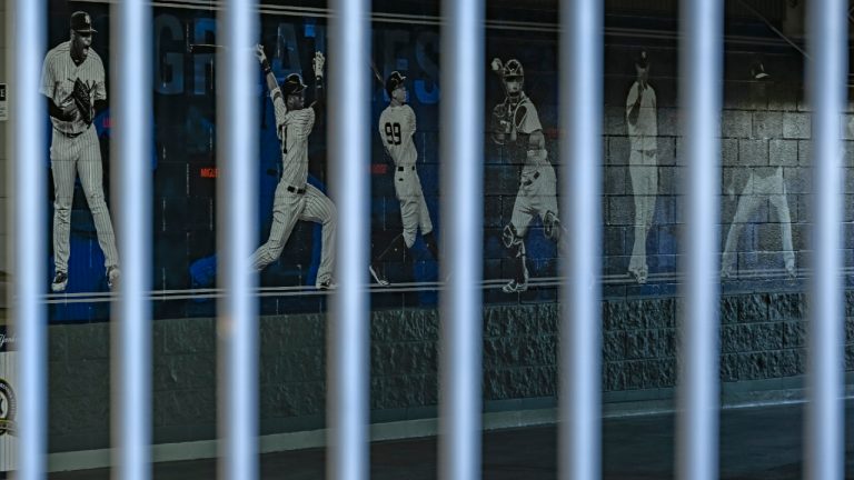  A mural of players adorns a wall behind a locked gate on the day pitchers and catcher were scheduled to report to camp at the New York Yankees spring training complex at George M. Steinbrenner Field Wednesday, Feb. 16, 2022, in Tampa, Fla. (Steve Nesius/AP) 