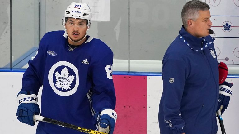 Toronto Maple Leafs forward Nicholas Robertson (89) watches his teammates take part in drills next to Maple Leafs head coach Sheldon Keefe, right, during their NHL training camp. (Nathan Denette/CP)