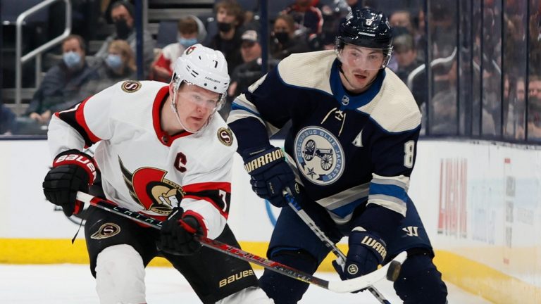 Ottawa Senators' Brady Tkachuk, left, dumps the puck as Columbus Blue Jackets' Zach Werenski defends during the third period of an NHL hockey game, Sunday, Jan. 23, 2022, in Columbus, Ohio. (Jay LaPrete/AP)