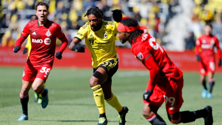 Columbus Crew defender Steven Moreira, center, dribbles the ball as Toronto FC forward Ifunanyachi Achara, right, defends during the first half of an MLS soccer match. (Joe Maiorana/AP)