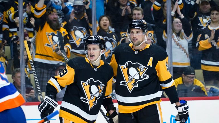 Jake Guentzel (59) is greeted by Brian Dumoulin (8) after scoring against the New York Islanders during the second period of an NHL hockey game Thursday, April 14, 2022, in Pittsburgh. (AP Photo/Keith Srakocic)