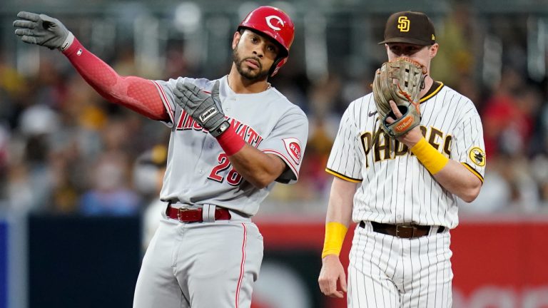 Cincinnati Reds' Tommy Pham, left, reacts after hitting a double as he stands alongside San Diego Padres second baseman Jake Cronenworth during the third inning of a baseball game Monday, April 18, 2022, in San Diego. (AP Photo/Gregory Bull)
