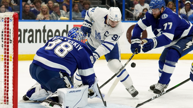Officials separate Toronto Maple Leafs forward Wayne Simmonds (24) and  Tampa Bay Lightning forward Corey Perry, right, as they fight during the  third period of Game 1 of an NHL hockey Stanley
