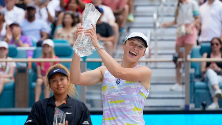 Iga Swiatek, right, of Poland, holds up her trophy after beating Naomi Osaka of Japan, left, 6-4, 6-0, during the women's singles finals of the Miami Open tennis tournament, Saturday, April 2, 2022, in Miami Gardens, Fla. (Wilfredo Lee/AP)