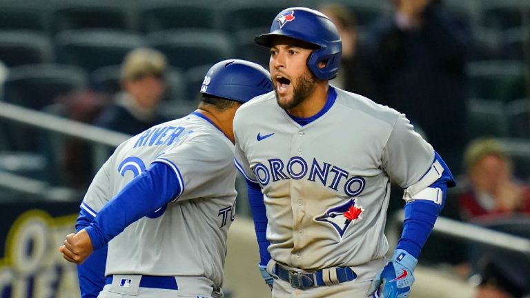 Toronto Blue Jays' George Springer, right, celebrates with third base coach Luis Rivera as he runs the bases after hitting a two-run home run during the third inning of a baseball game against the New York Yankees, Monday, April 11, 2022, in New York. (Frank Franklin II/AP)