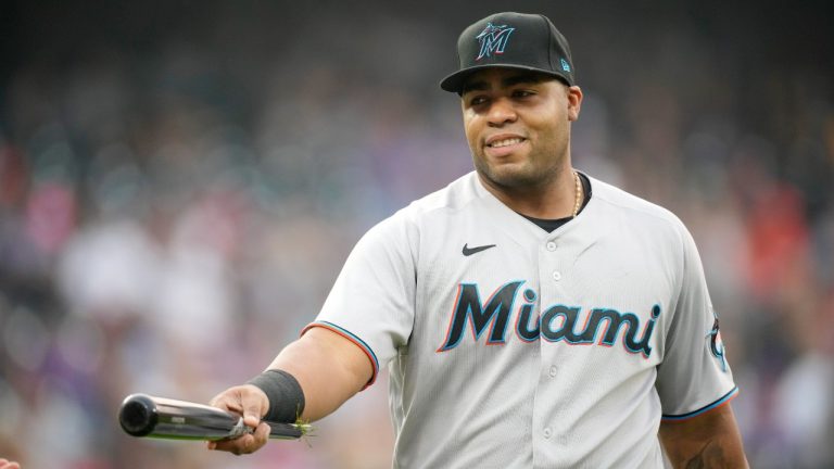Miami Marlins first baseman Jesus Aguilar hands the shattered bat, used by Colorado Rockies' Charlie Blackmon while hitting a single, to a bat boy in the fourth inning of a baseball game Saturday, Aug. 7, 2021, in Denver. (David Zalubowski/AP)