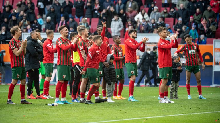 Augsburg players celebrate their 3-0 win with the fans after a German Bundesliga soccer match between FC Augsburg and VfL Wolfsburg. (Matthias Balk/AP)