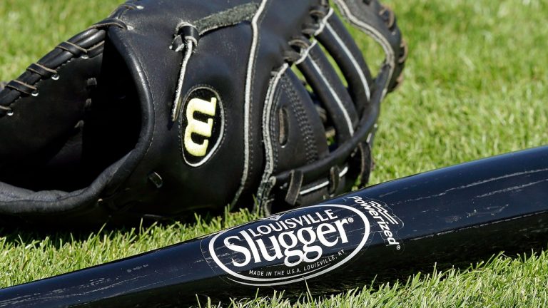 A Wilson baseball glove and a Louisville slugger bat sit on the field prior to a spring training baseball game between the Kansas City Royals and the San Francisco Giants on Monday, March 23, 2015, in Scottsdale, Ariz. (Ben Margot/AP Photo)
