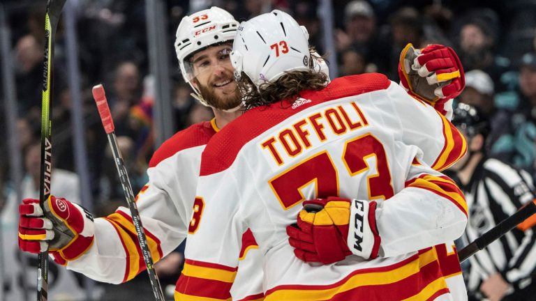 Calgary Flames defenseman Noah Hanifin, left, and forward Tyler Toffoli celebrate and empty-net short-handed goal during the third period of an NHL hockey game against the Seattle Kraken. (AP)