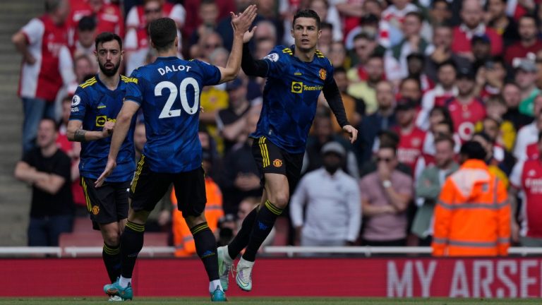 Manchester United's Cristiano Ronaldo, right, celebrates after scoring his side's first goal during an English Premier League soccer match between Arsenal and Manchester United at the Emirates stadium in London, Saturday April 23, 2022. (Alastair J. Grant/AP)