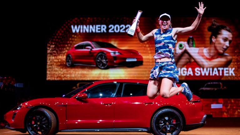 Poland's Iga Swiatek celebrates during the award ceremony and jumps into the air with the trophy after winning the Stuttgart Open tennis tournament in Stuttgart, Germany, Sunday April 24, 2022, (Tom Weller/DPA via AP)