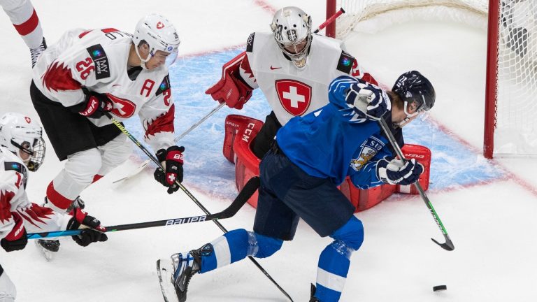 Finland's Roni Hirvonen (22) is stopped by Switzerland goalie Thibault Fatton (29) as Rocco Pezzullo (26) defends during second period IIHF World Junior Hockey Championship action in Edmonton on Sunday, Dec. 27, 2020. (Jason Franson/THE CANADIAN PRESS)