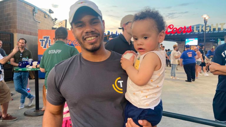 Alan Alcantara holds his 1-year-old son, Levi, at the New York Mets' baseball game against the Washington Nationals on Tuesday, May 31, 2022, in New York. (Jake Seiner/AP)